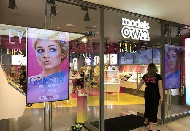 Pantalla LED vertical en el escaparate de una tienda de cosmética